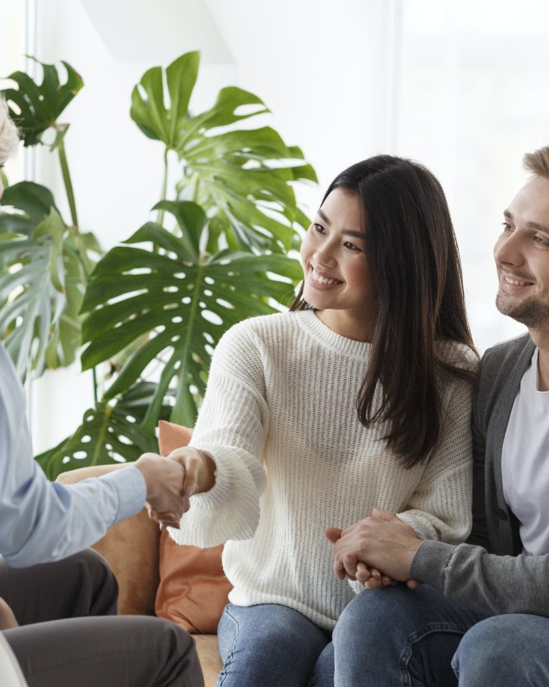 couple-shaking-hands-with-counselor-thankful-for-help-in-office.jpg